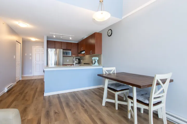 Kitchen featuring tasteful backsplash, light countertops, stainless steel appliances, a peninsula, and wood finished floors