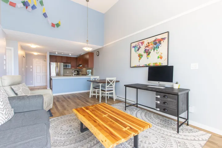 Living room featuring light wood finished floors and a high ceiling