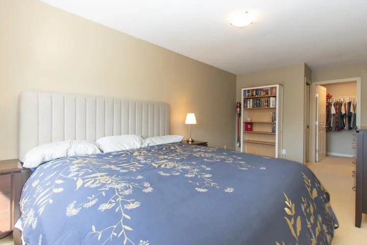 Carpeted bedroom with a walk in closet