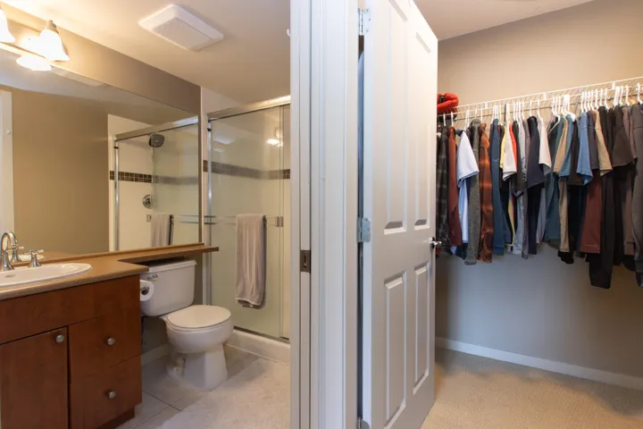 Full bath featuring vanity, a shower stall, and a spacious closet