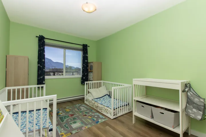 Bedroom with a crib, wood finished floors, and a mountain view