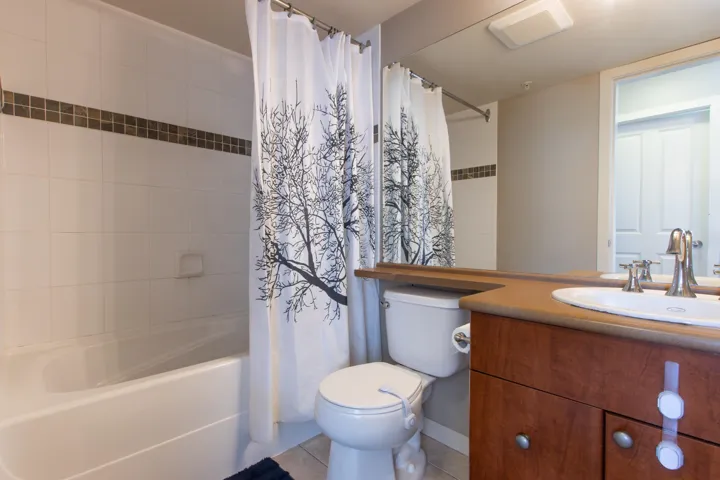 Full bathroom with shower / bath combo, vanity, and light tile patterned floors