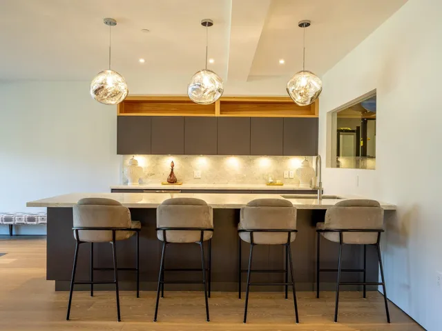 Kitchen with decorative backsplash, a breakfast bar area, light wood-style flooring, a peninsula, and recessed lighting