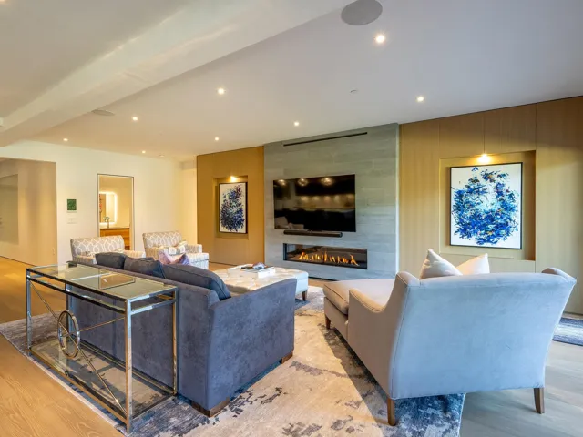 Living room featuring wood finished floors, recessed lighting, a large fireplace, and wooden walls