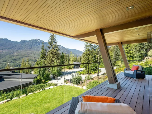 Wooden deck with a mountain view, a forest view, and a lawn