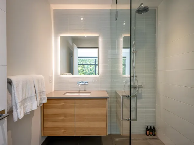 Full bathroom featuring a shower stall, vanity, dark tile patterned floors, and tile walls