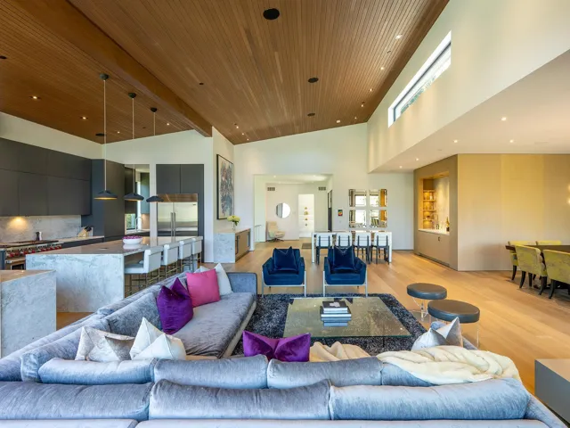 Living room with a wooden ceiling with exposed beams, light wood-style flooring, a high ceiling, recessed lighting, and healthy amount of natural light