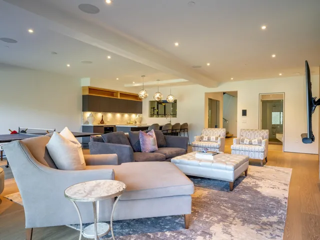 Living room with wood finished floors, beam ceiling, and recessed lighting