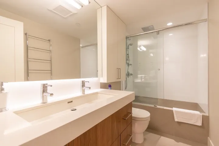 Bathroom featuring vanity, shower / bath combination with glass door, recessed lighting, and radiator