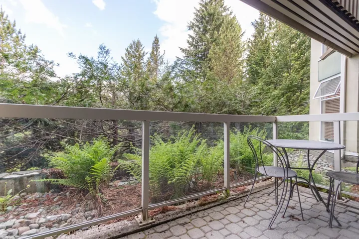 Balcony featuring view of wooded area