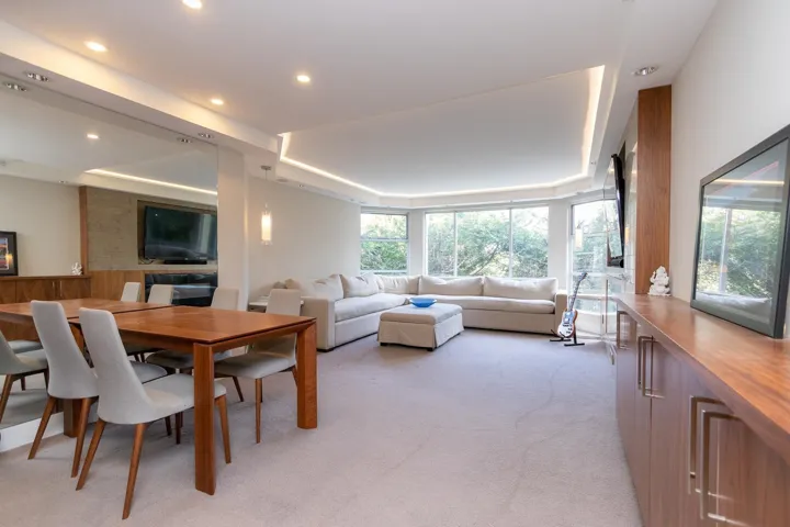 Dining space with a tray ceiling and light carpet