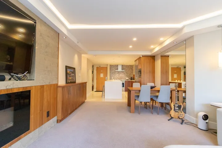 Dining room with recessed lighting, light colored carpet, a tray ceiling, and a fireplace