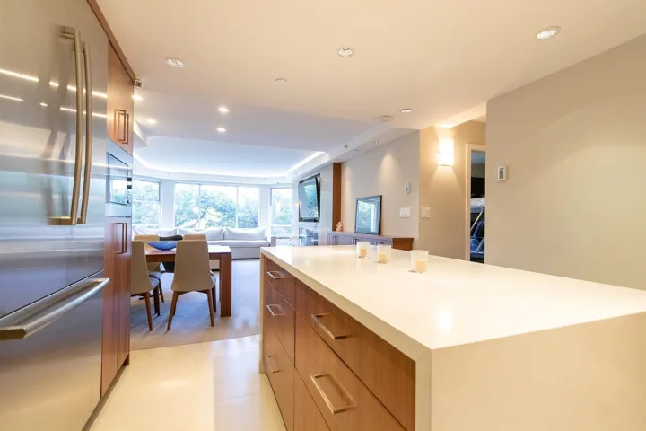 Kitchen featuring stainless steel appliances, modern cabinets, brown cabinetry, recessed lighting, and a kitchen island