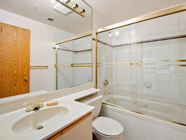 Full bath with tiled shower / bath combo, toilet, and vanity