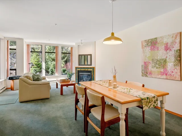Dining room featuring baseboards, carpet, and a glass covered fireplace