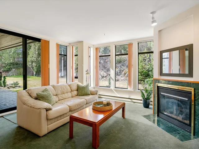 Living room with a high end fireplace, plenty of natural light, and baseboard heating
