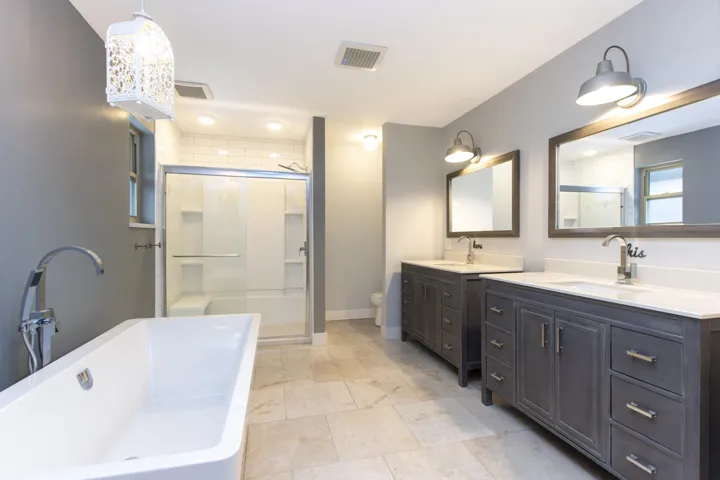 Full bath with a soaking tub, two vanities, and a stall shower