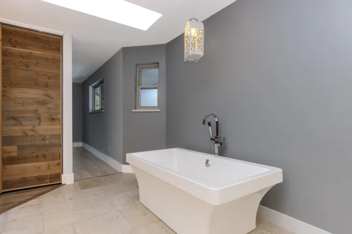Full bathroom with a freestanding tub and a skylight
