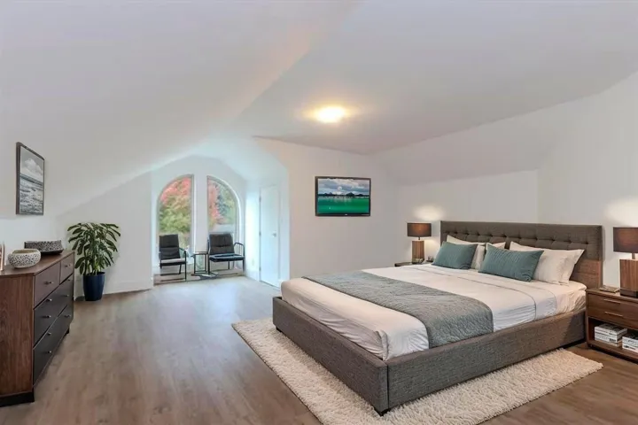 Bedroom featuring light wood finished floors and lofted ceiling