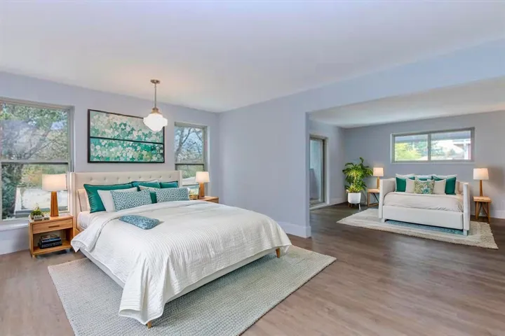 Bedroom with wood finished floors and multiple windows
