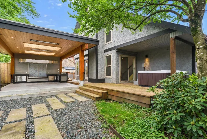 Entrance to property with a hot tub, stucco siding, and a wooden deck