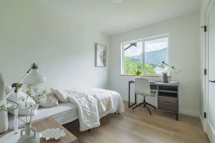 Bedroom featuring light wood finished floors, a mountain view, and a desk