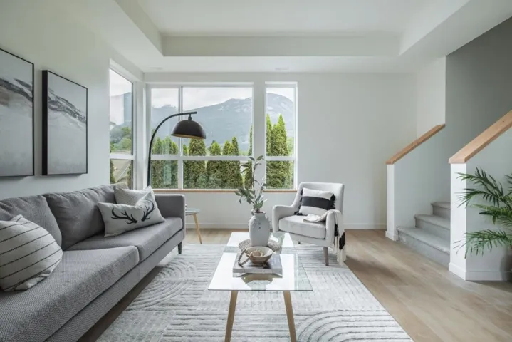 Living area with a tray ceiling, stairs, wood finished floors, and a mountain view
