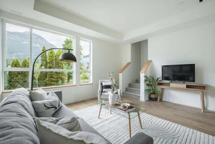 Living room featuring wood finished floors, a raised ceiling, a mountain view, and stairway