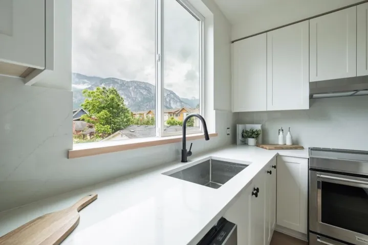 Kitchen with stainless steel range with electric stovetop, white cabinetry, a mountain view, under cabinet range hood, and light stone counters