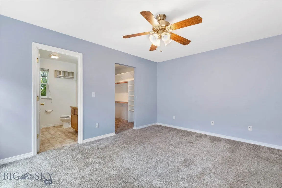 Primary bedroom looking into en-suite bathroom and walk-in closet