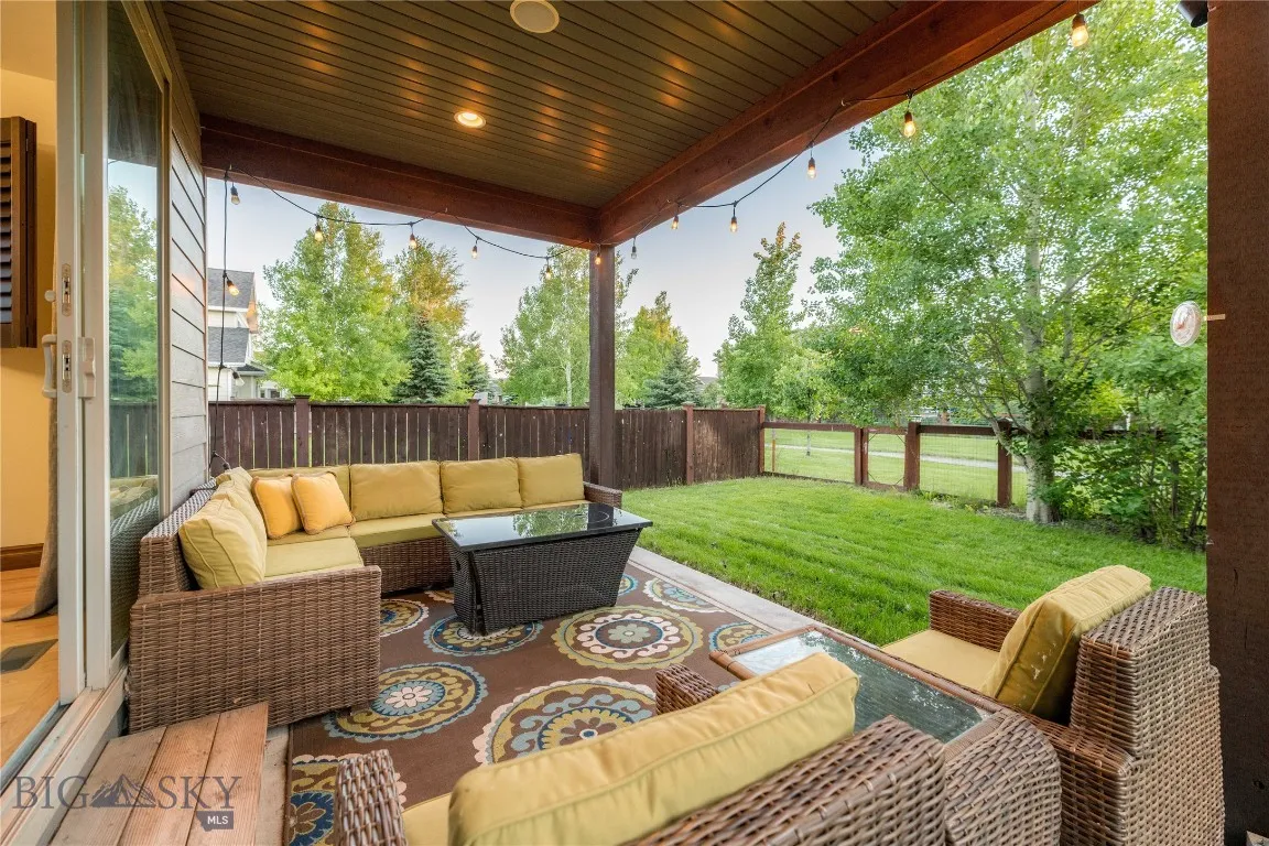 Private back patio with mature trees and landscaping