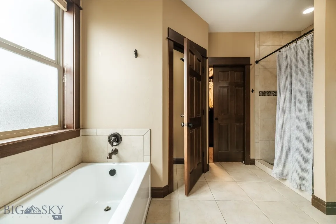 Main floor master bath with tiled shower, walk in closet with built-ins & separate water closet