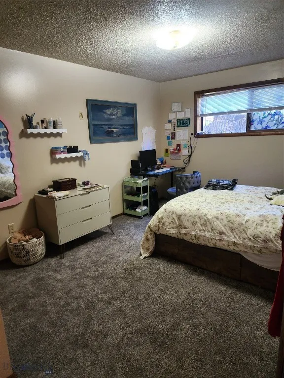 Bedroom featuring carpet and a textured ceiling