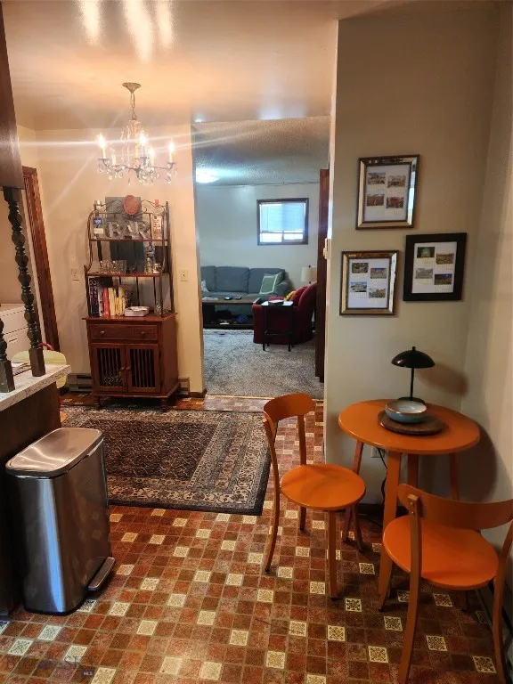 Carpeted dining room featuring a chandelier
