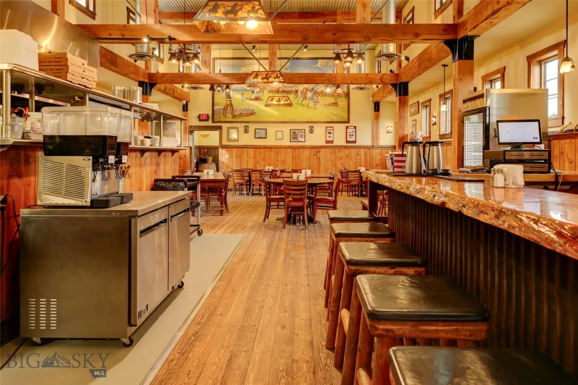 Kitchen with decorative light fixtures, beam ceiling, and light wood-type flooring
