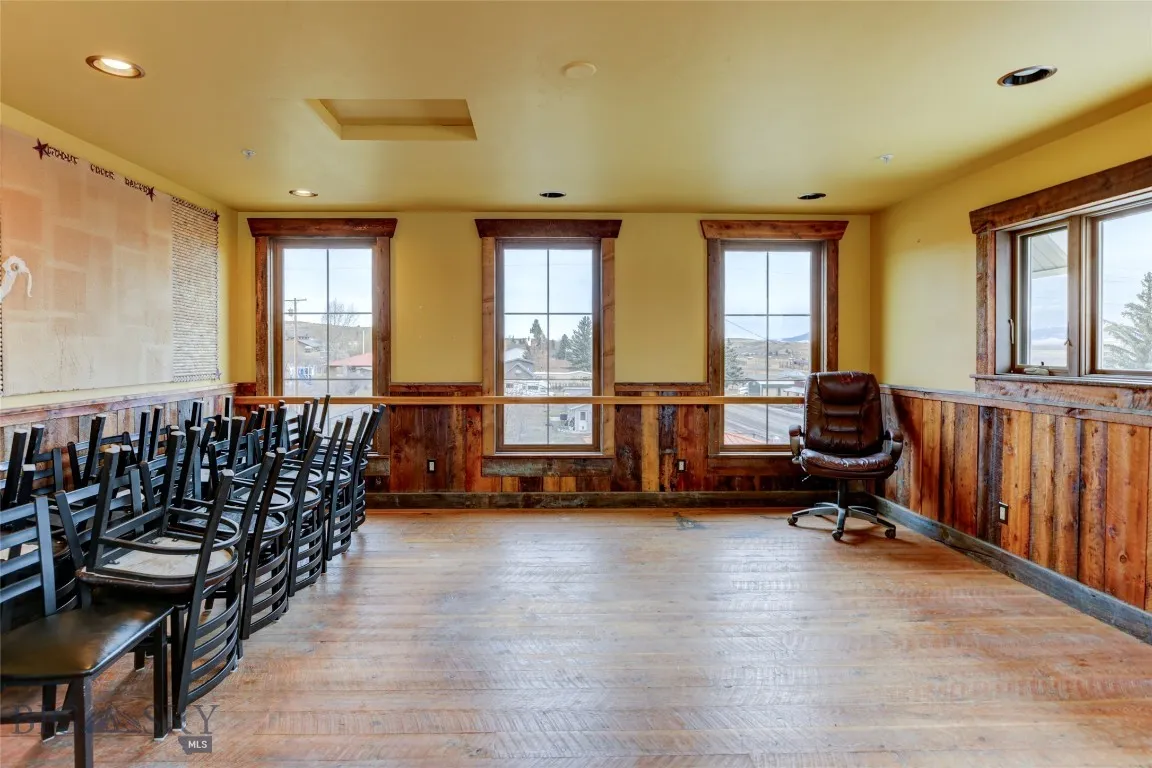 Miscellaneous room with light hardwood / wood-style floors and wood walls