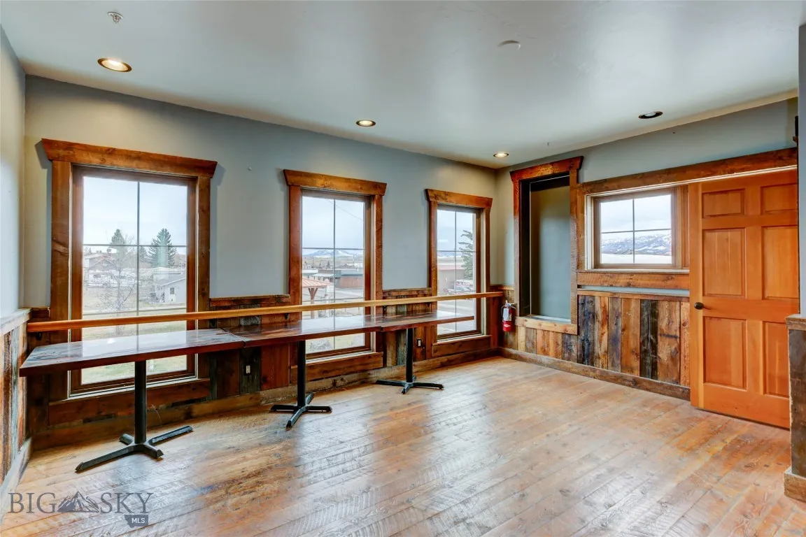 2nd level with light wood-type flooring, wooden walls, and a healthy amount of sunlight