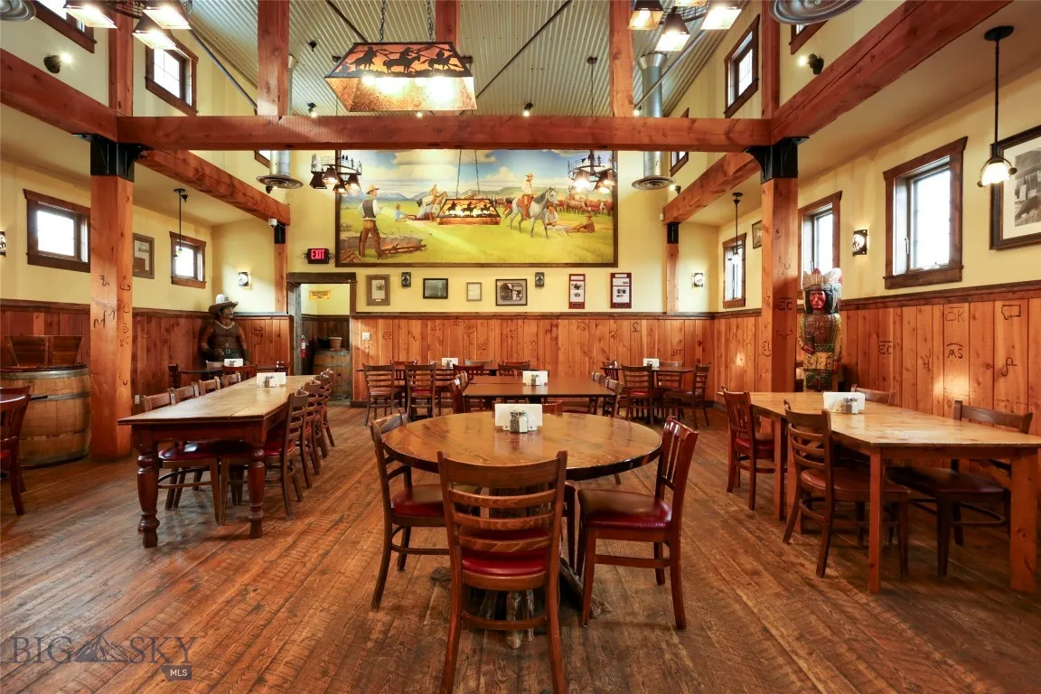 Dining room with wood walls, a high ceiling, and dark hardwood / wood-style floors