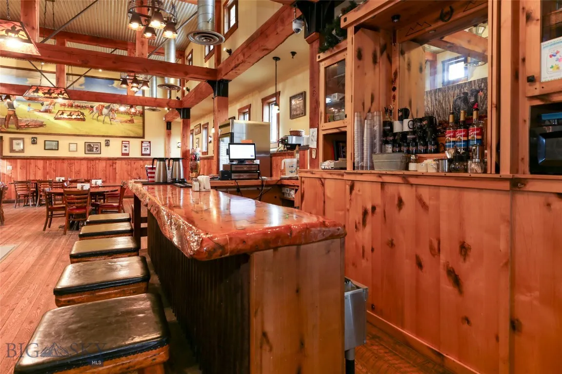 Kitchen featuring pendant lighting, a towering ceiling, hardwood / wood-style flooring, and wood walls