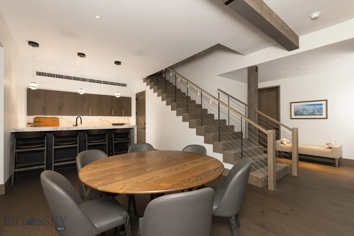 Dining area featuring beamed ceiling, dark hardwood / wood-style floors, and indoor wet bar