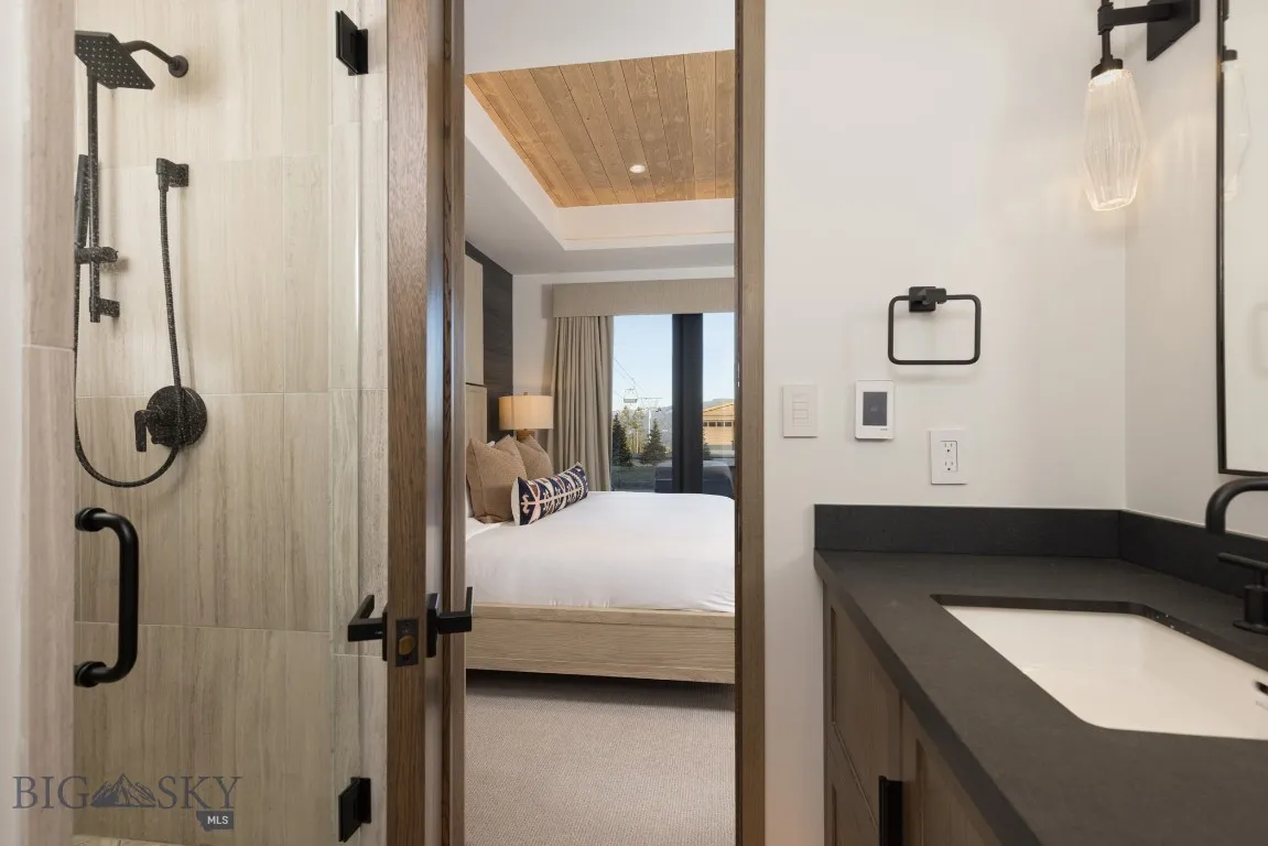 Bathroom featuring vanity, a tray ceiling, walk in shower, and wood ceiling