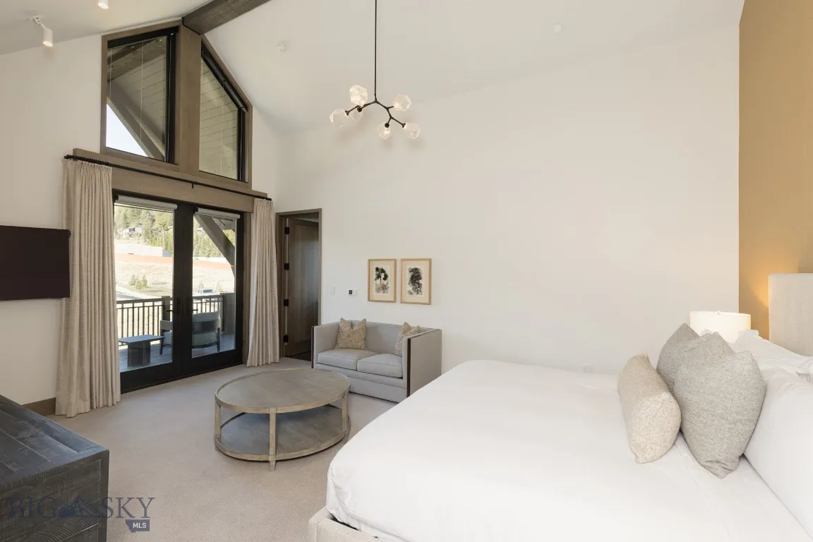Bedroom with high vaulted ceiling, an inviting chandelier, access to exterior, beamed ceiling, and light colored carpet