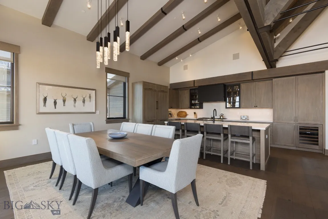 Dining space featuring sink, beverage cooler, beamed ceiling, high vaulted ceiling, and dark hardwood / wood-style floors