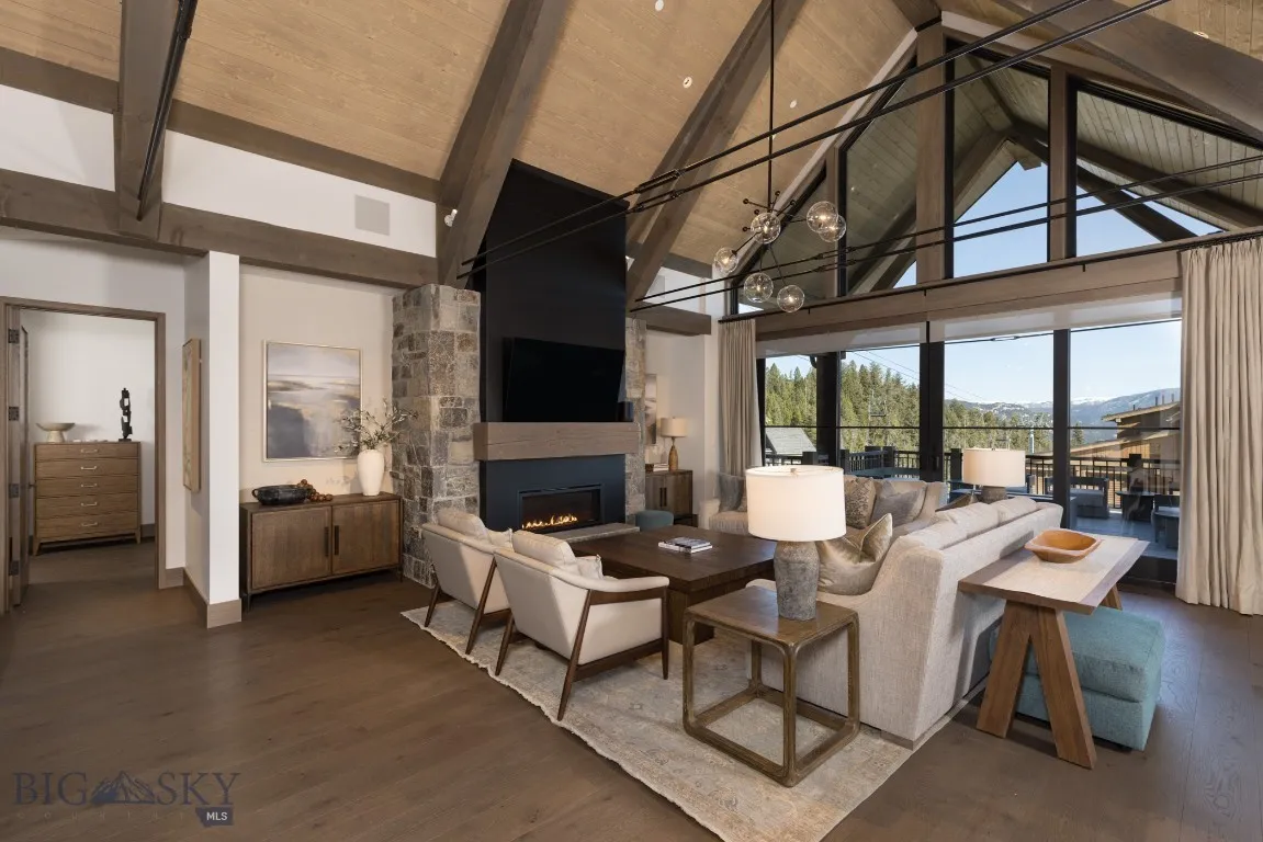 Living room with dark hardwood / wood-style flooring, wooden ceiling, high vaulted ceiling, and a stone fireplace