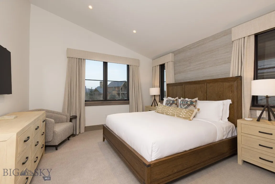 Bedroom with light carpet and vaulted ceiling