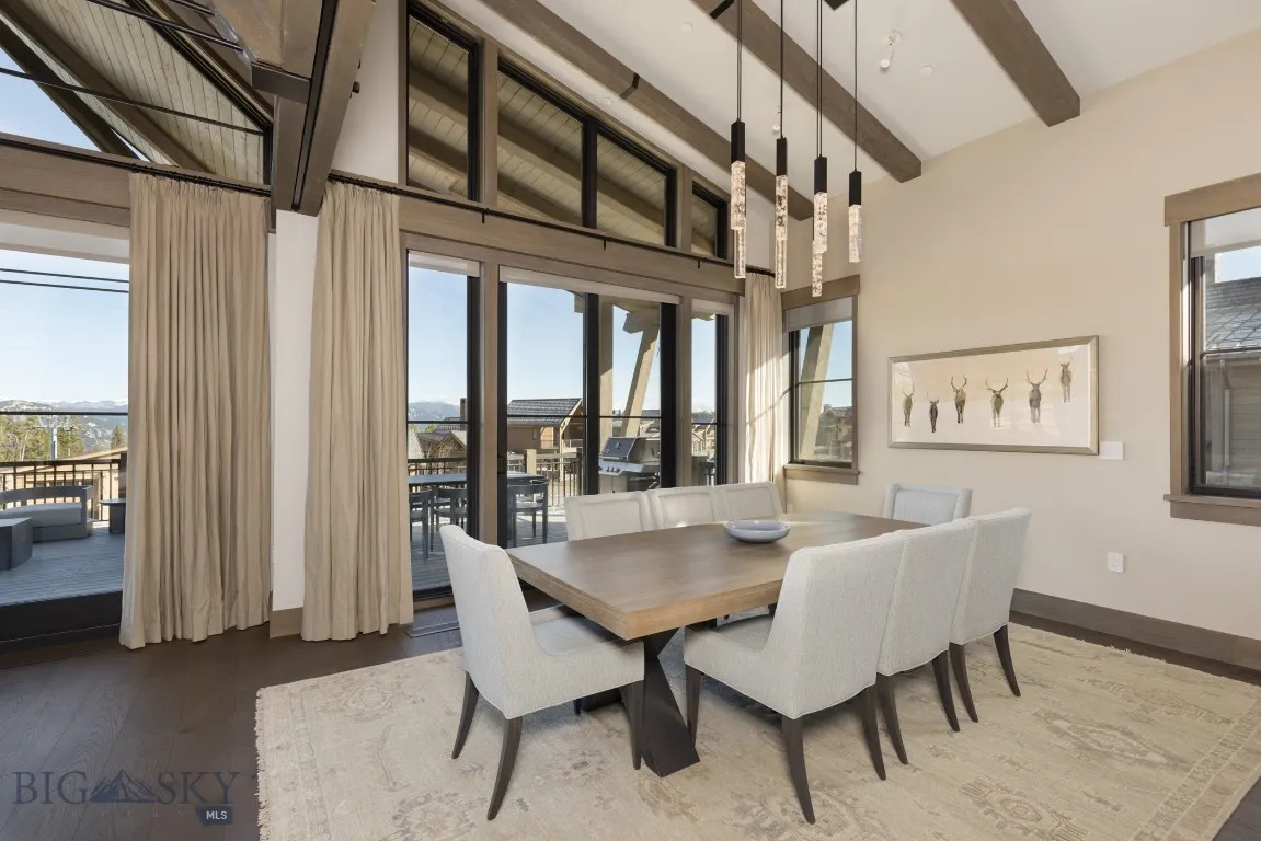 Dining space featuring plenty of natural light, high vaulted ceiling, beamed ceiling, and hardwood / wood-style flooring