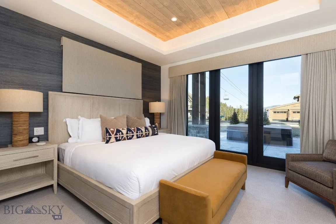 Bedroom featuring access to exterior, wood ceiling, light carpet, and a tray ceiling