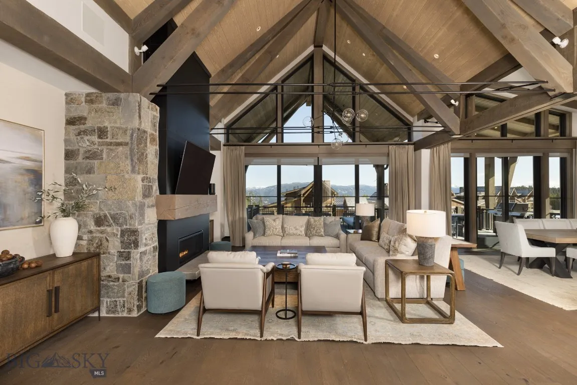 Living room featuring a tile fireplace, beamed ceiling, high vaulted ceiling, and dark hardwood / wood-style floors