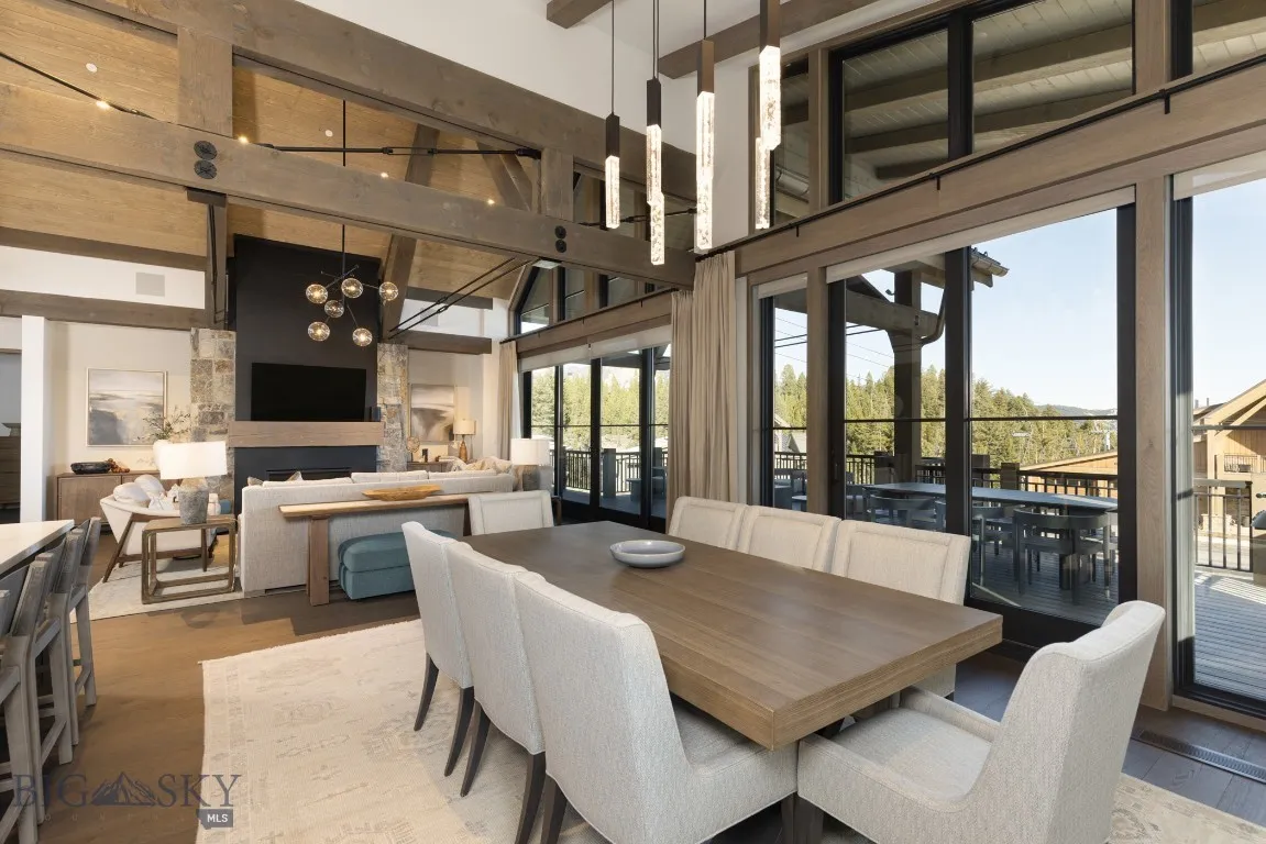 Dining area with a fireplace, hardwood / wood-style flooring, high vaulted ceiling, beamed ceiling, and a chandelier