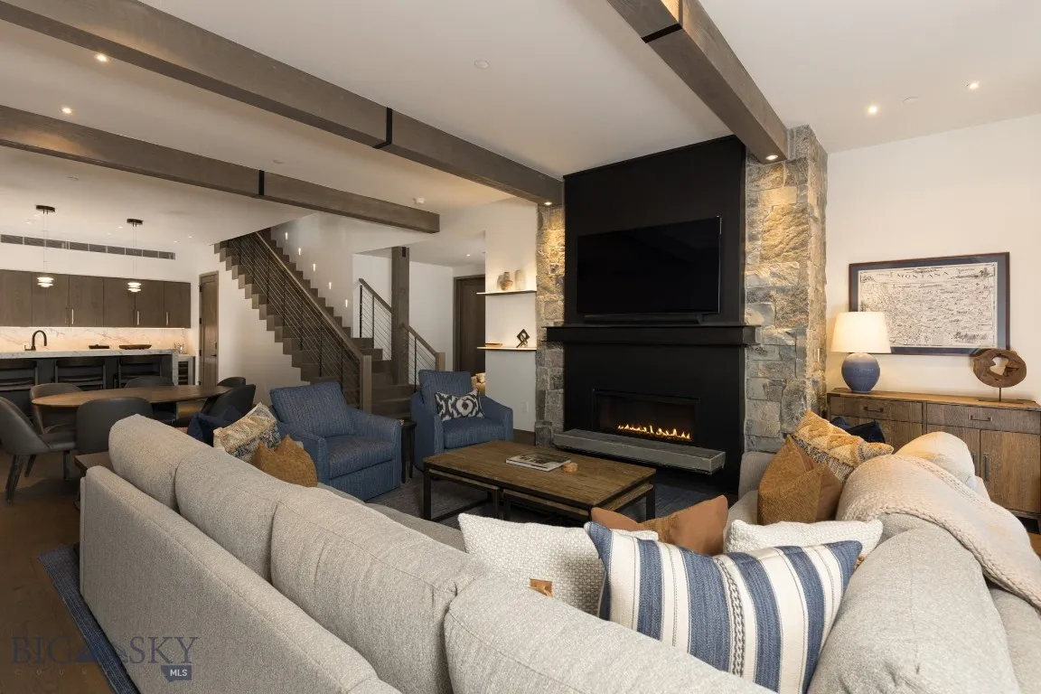 Living room featuring beamed ceiling, hardwood / wood-style floors, a fireplace, and sink